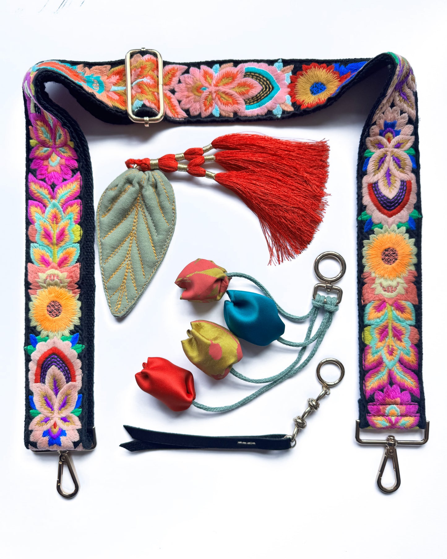 Leather bag with embroidered strap and decorative keychain