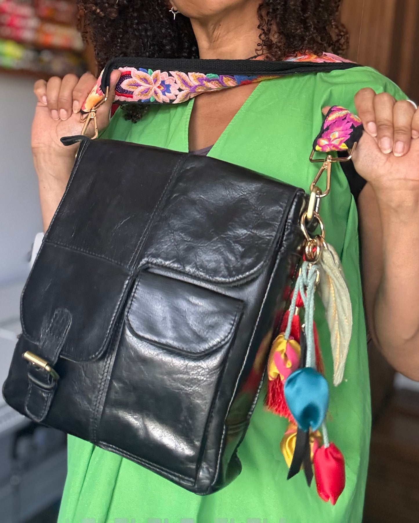 Leather bag with embroidered strap and decorative keychain
