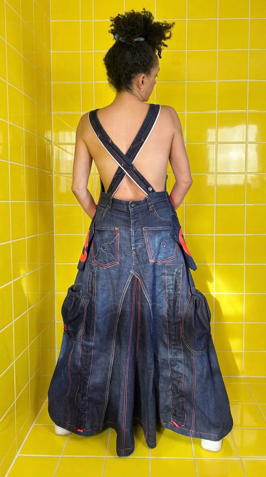 A one-of-a-kind reworked Adidas denim pinafore dress, created from quality vintage denim jeans and a vibrant neon orange Adidas logo tee.