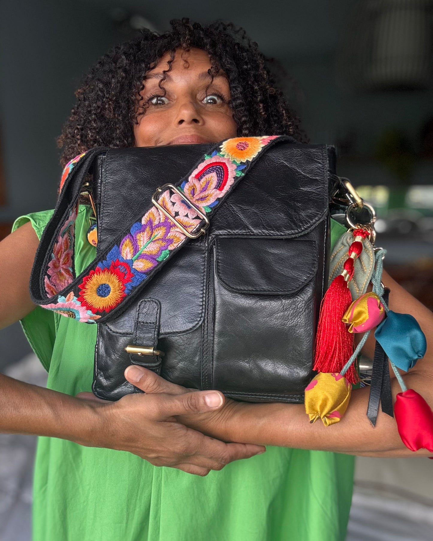 Leather bag with embroidered strap and decorative keychain